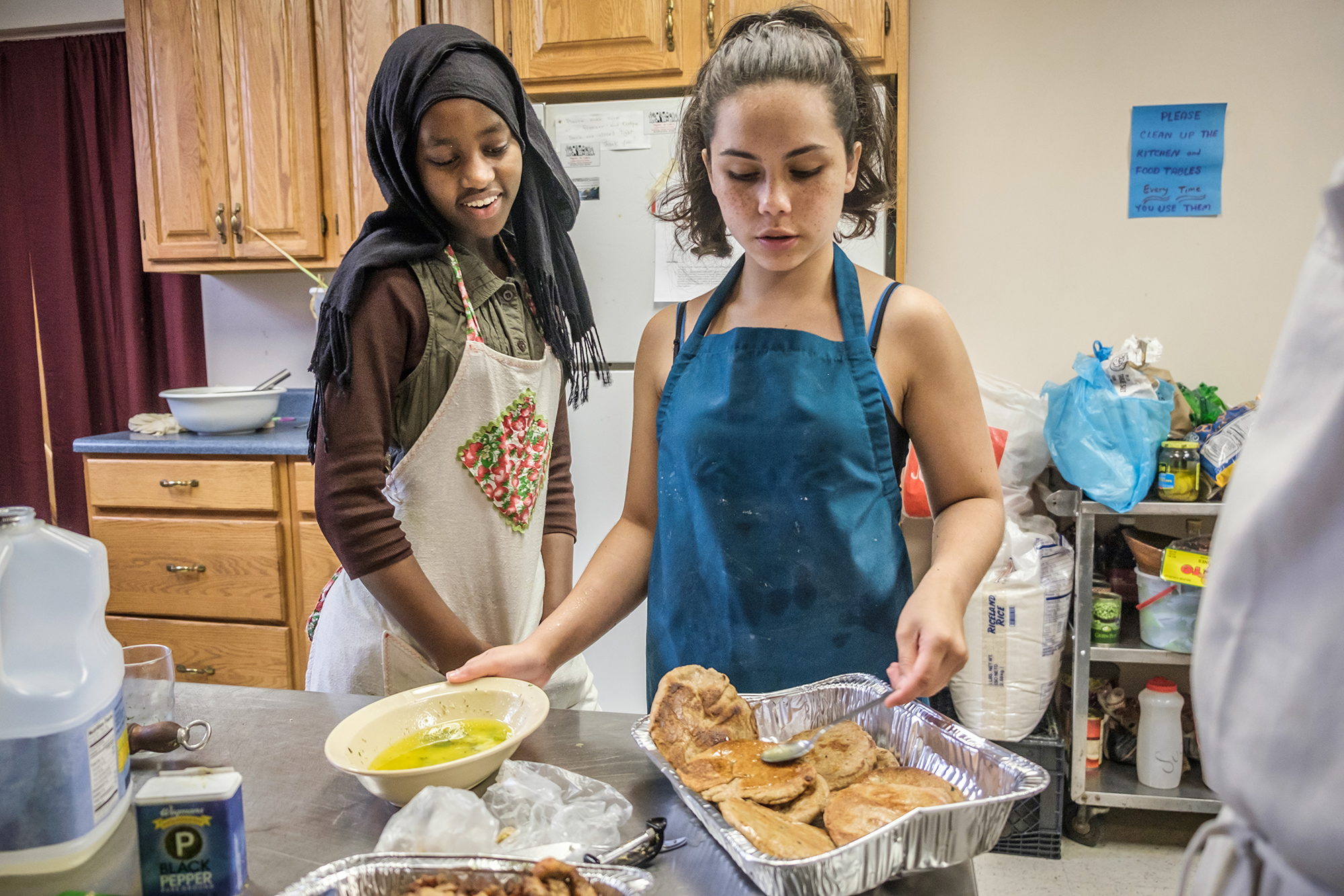 two women making food in a kitchen