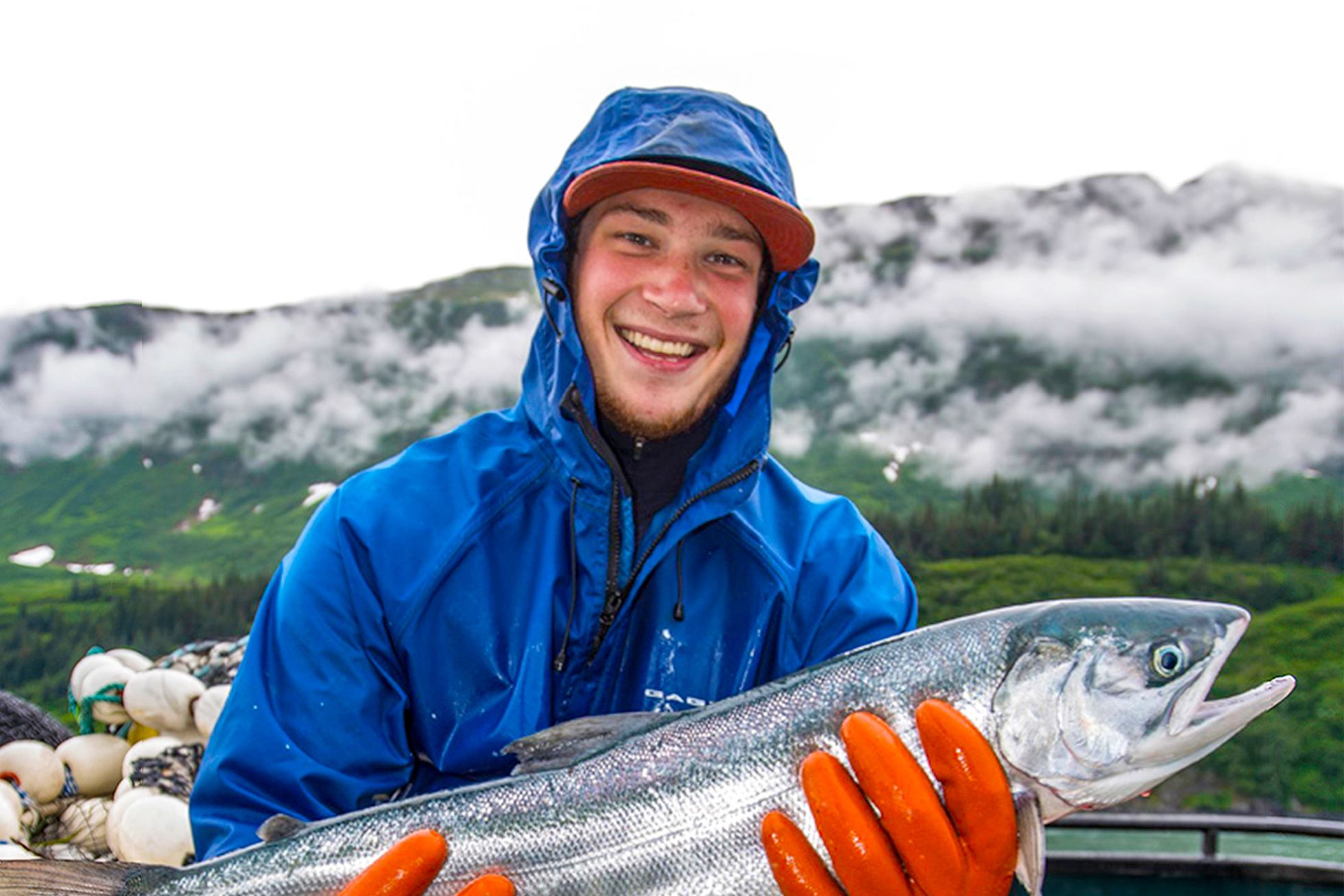 man smiling holding a fish