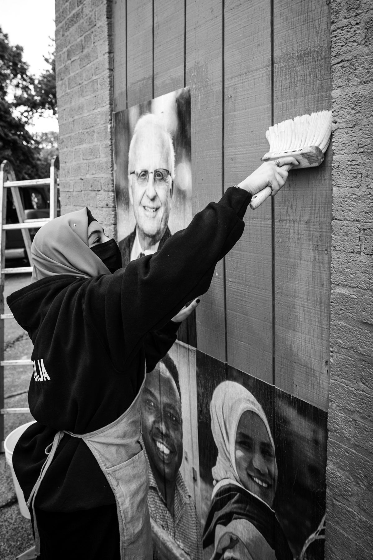 woman using a paintbrush to paint the building's wall